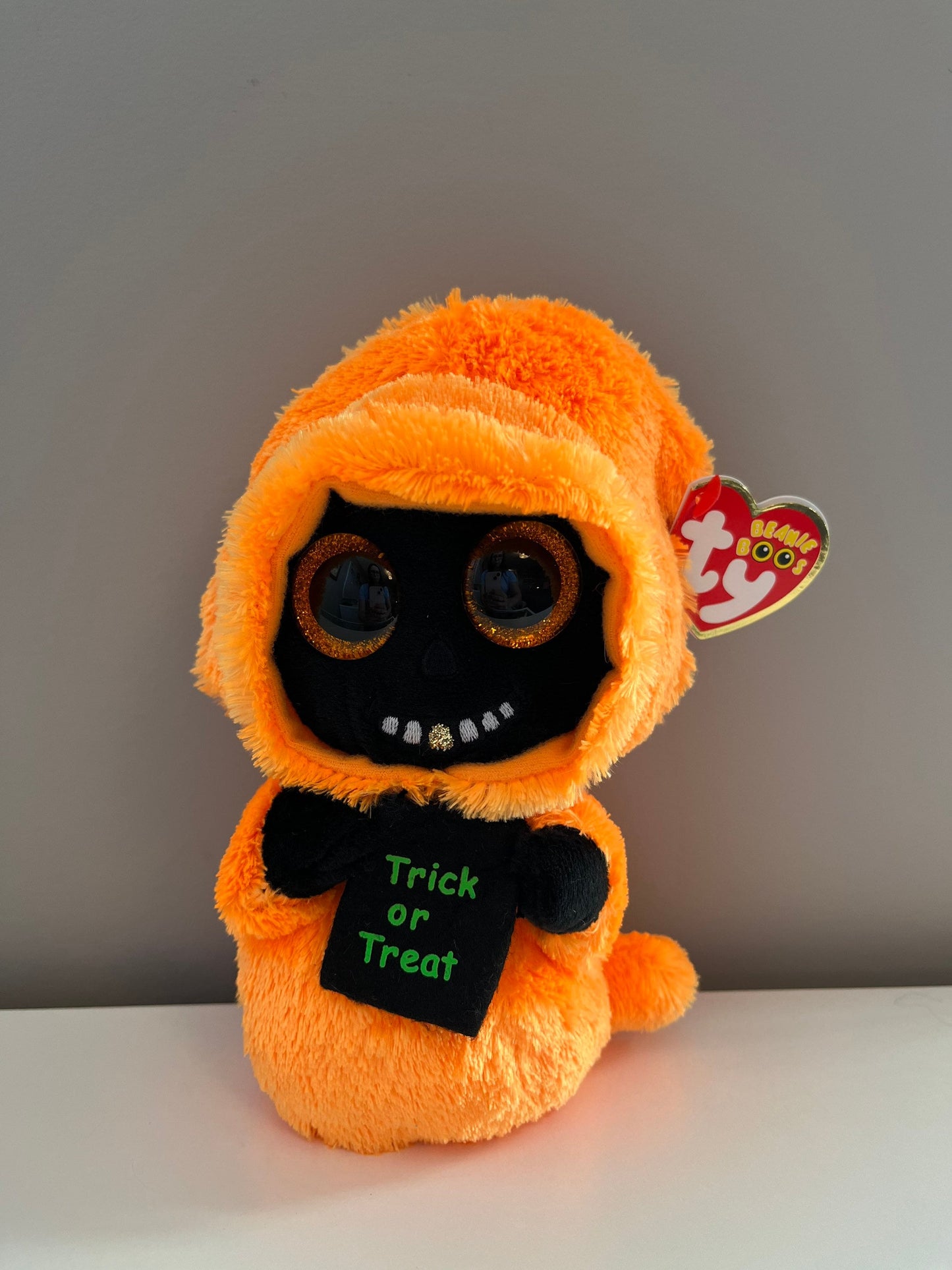 Ty Beanie Boo “Grinner” the Orange and Black Ghoul holding Trick or Treat Bag (6 inch)