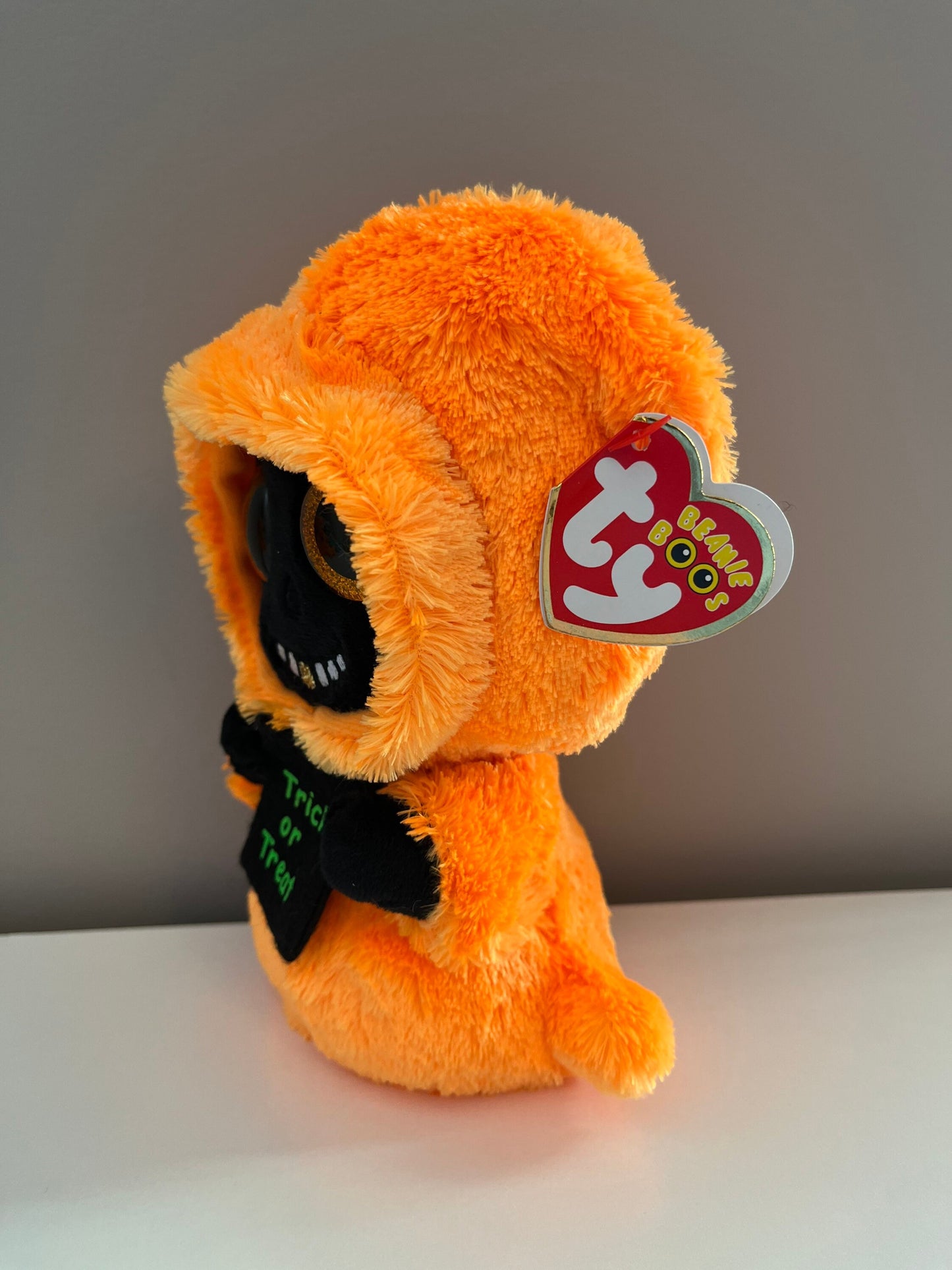 Ty Beanie Boo “Grinner” the Orange and Black Ghoul holding Trick or Treat Bag (6 inch)